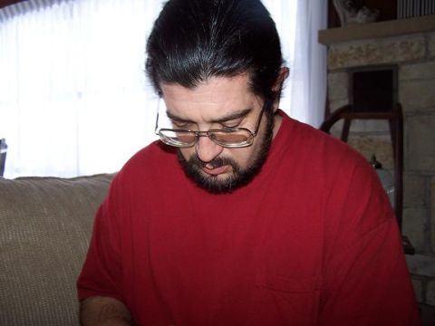 2000 Ford Crown Victoria - A man wearing glasses and a red shirt is looking down. The Supermotors website logo is visible in the lower right corner.