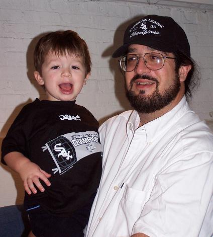 2000 Ford Crown Victoria - A man holds a child in front of a white brick wall.