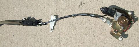 1992 Ford Probe - Door latch mechanism with motor and cable assembly shown on concrete.