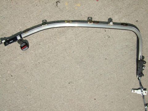 1992 Ford Probe - A car's door frame, including the window track and a seatbelt buckle, lies on a concrete surface.