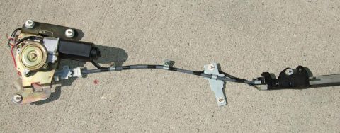 1992 Ford Probe - A power window regulator assembly is shown laid out on a concrete surface.
