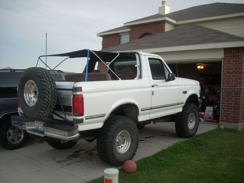 1992 Ford Bronco - This 1992 Ford Bronco is seen from a three-quarter front angle, parked in front of a brick house.