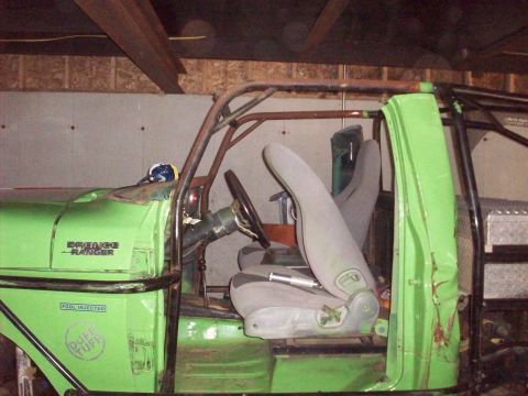 1978 Ford Bronco - Interior view of a heavily modified green off-road vehicle with a roll cage and custom seats.
