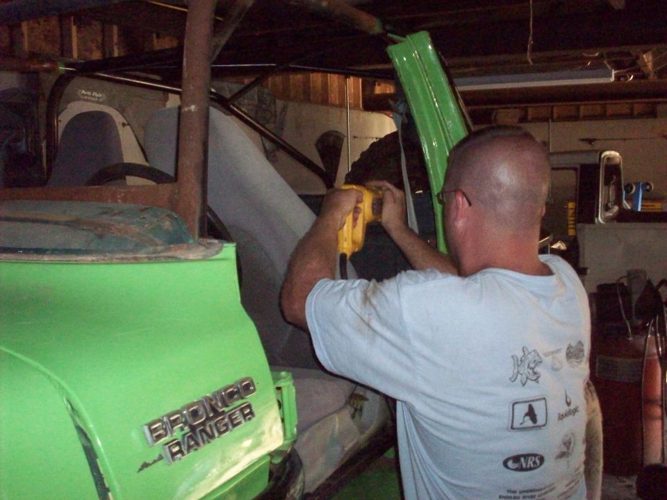 Green 1978 Ford Bronco Ranger interior with man working on dashboard