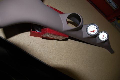 1996 Ford Bronco - Photograph of a gauge pod fitted with two Auto Meter gauges resting on a work surface.