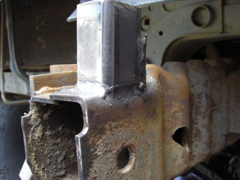 1993 Ford Bronco - This close-up shows a newly welded metal bracket attached to a heavily rusted vehicle frame, indicating repair or modification work.