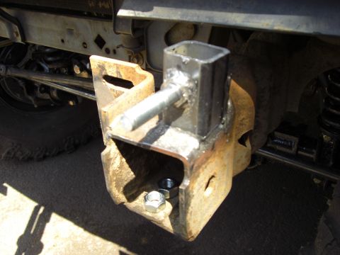1993 Ford Bronco - Close-up of a rusty trailer hitch receiver assembly, showing welded metal and hardware.