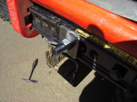 1993 Ford Bronco - A hi-lift jack is mounted to the vehicle's frame, secured by a bolt and metal plate.