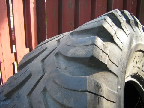 1990 Ford Bronco - A close-up view of a tire's aggressive tread pattern, with partial text reading 'CHAMPION' visible on the sidewall.