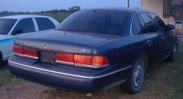 Dark blue sedan, rear 3/4 view, with chrome trim and tinted windows