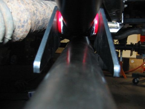 1995 Ford Bronco - Underside view of suspension components, red bushings and metal brackets.