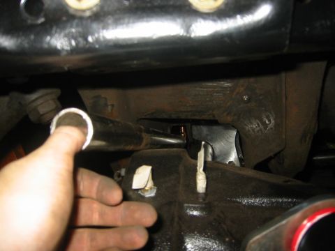 1995 Ford Bronco - Close-up view of a vehicle's undercarriage with a hand holding a metal pipe. The Supermotors.net logo is visible in the lower right corner.