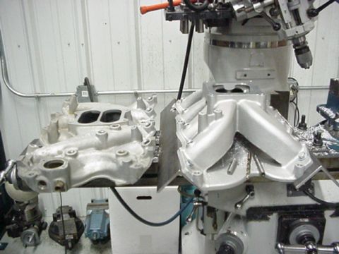1979 Ford Bronco - Two aluminum intake manifolds are positioned on a milling machine, likely for modification or repair.