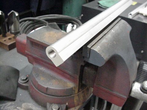 1979 Ford Bronco - A metal component is secured in a vise, likely for modification or repair.