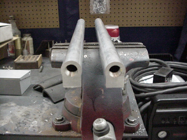 Two aluminum tubes held in a vise on a workbench