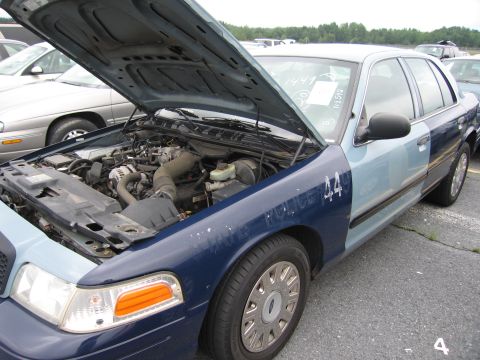 2001 Ford Crown Victoria - Front passenger side view of a 2001 Ford Crown Victoria with its hood open, revealing the engine bay.