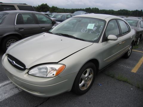 2001 Ford Crown Victoria - A silver sedan is parked in an outdoor lot, with other vehicles visible in the background.