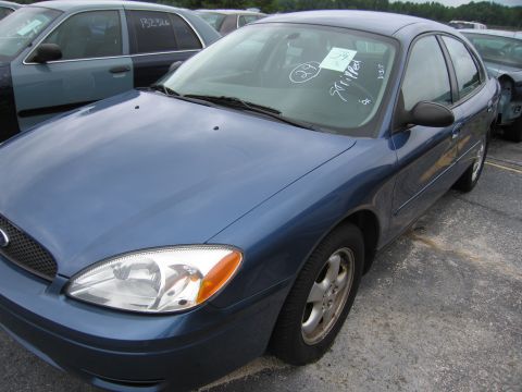 2001 Ford Crown Victoria - Blue sedan with handwritten notes on the windshield, parked in an outdoor lot.