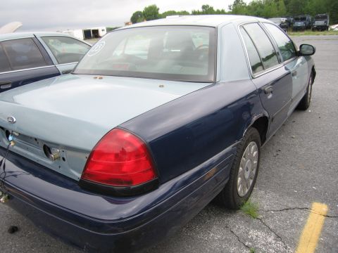 2001 Ford Crown Victoria - This Ford Crown Victoria has a two-tone paint job and appears to be in a junkyard or impound lot.