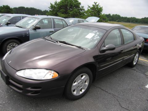 2001 Ford Crown Victoria - A dark purple sedan is parked in a lot with other vehicles. Handwritten notes are visible on the windshield.
