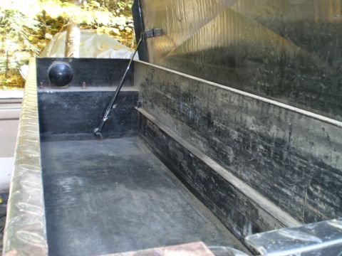 1979 Ford Bronco - The interior of a truck bed is shown with the lid open, revealing its storage space.