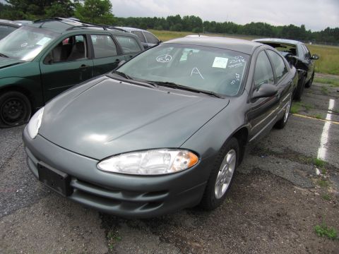 2001 Ford Crown Victoria - Sedan with windshield sticker "03 2348" sits in a lot next to a green wagon.