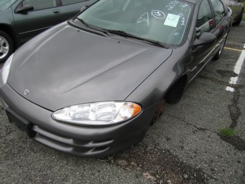 2001 Ford Crown Victoria - Gray Dodge Intrepid with missing wheel, parked next to another vehicle.