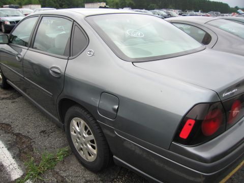 2001 Ford Crown Victoria - A gray sedan is parked in a lot with other vehicles, viewed from the rear quarter panel.