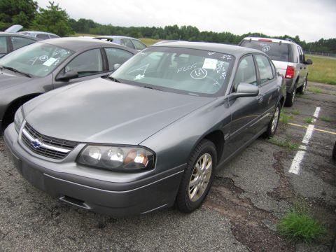 2001 Ford Crown Victoria - A gray sedan is parked in an outdoor lot, with other vehicles visible in the background.