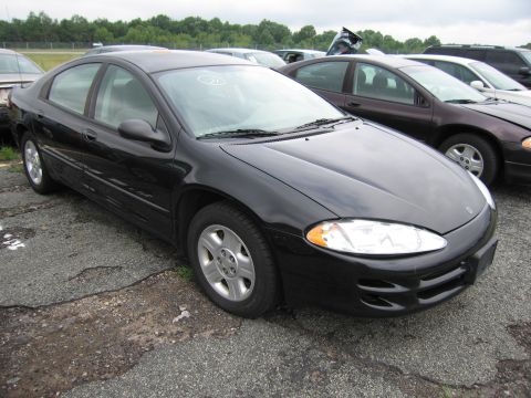 2001 Ford Crown Victoria - A black sedan sits in a lot with cracked pavement and other vehicles in the background.