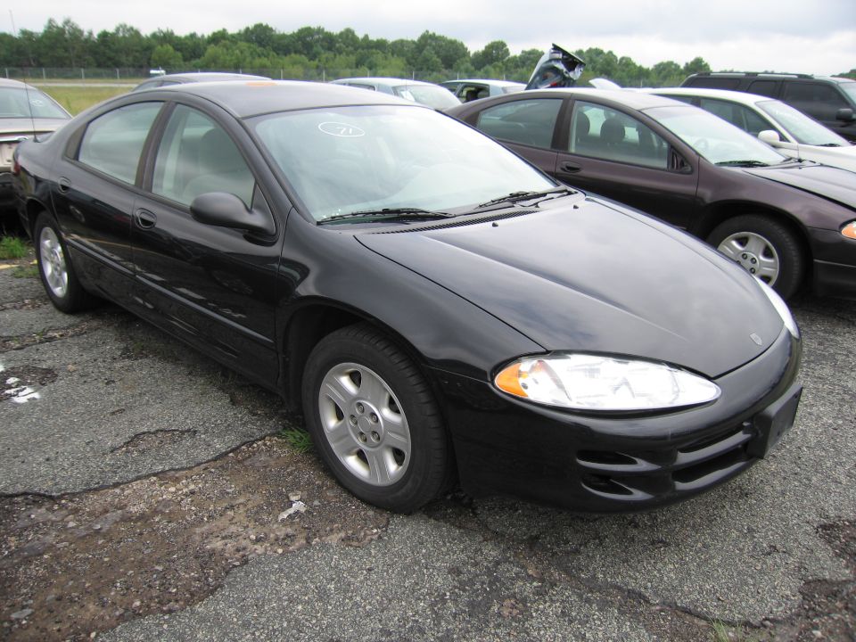 Black sedan parked in a lot with other cars. Front passenger side visible