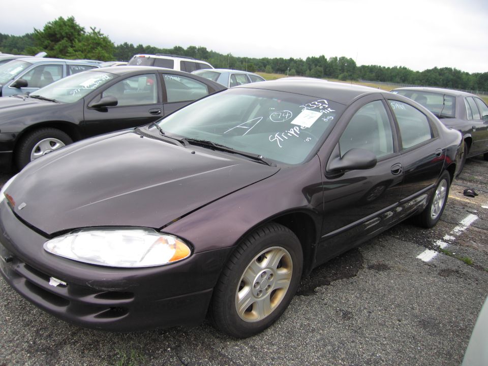 Dark purple sedan with white writing on windshield parked in a lot with other cars