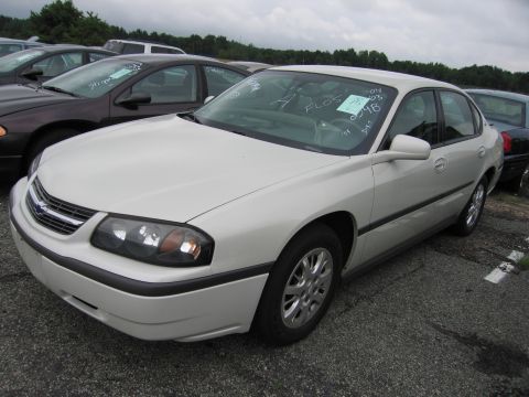2001 Ford Crown Victoria - A white sedan is parked in an outdoor lot with other vehicles visible in the background.