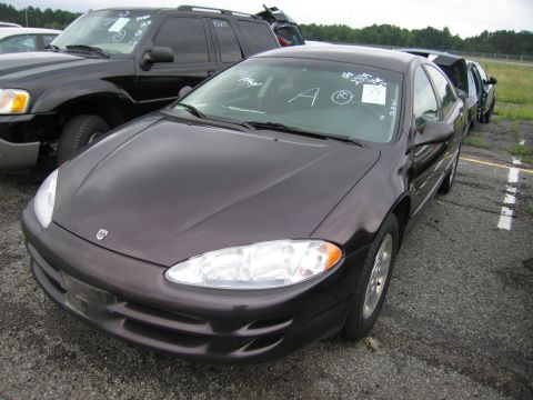 2001 Ford Crown Victoria - A dark purple sedan is parked in a lot with other vehicles. White markings are visible on the windshield.