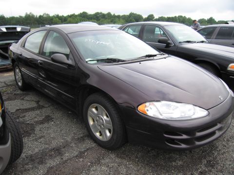 2001 Ford Crown Victoria - A dark sedan is parked in an outdoor lot with other vehicles visible in the background.