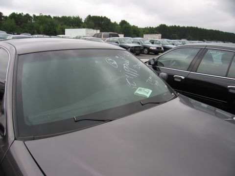 2001 Ford Crown Victoria - A 2001 Ford Crown Victoria is parked in a lot with other vehicles, its windshield marked with writing.
