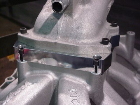 1979 Ford Bronco - Close-up of an engine intake manifold part with a polished spacer.