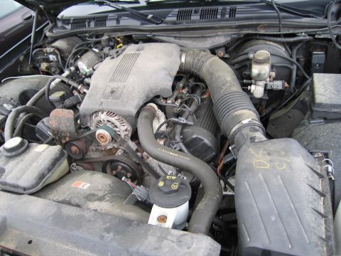 2001 Ford Crown Victoria - Close-up view of the engine compartment of a 2001 Ford Crown Victoria, revealing its V8 engine and associated components.