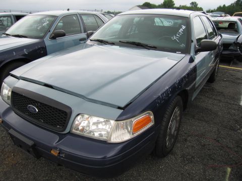 2001 Ford Crown Victoria - Two-tone Ford Crown Victoria in a car lot with other vehicles visible in the background.