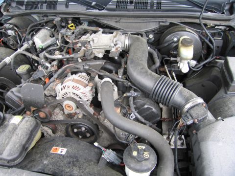 2001 Ford Crown Victoria - Close-up view of a car's engine compartment, showing various mechanical components and wiring.