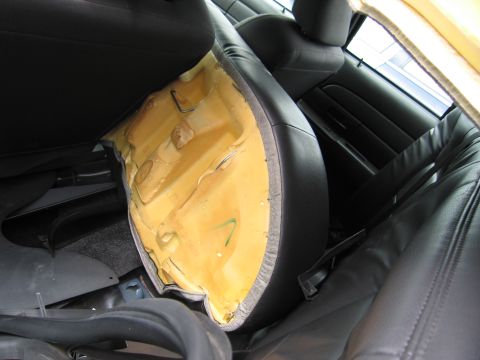 2001 Ford Crown Victoria - Interior view of a car with damaged seat cushioning and black leather seats.