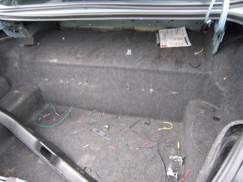 2001 Ford Crown Victoria - Trunk interior with wiring and a manual visible. No vehicle year is discernible.
