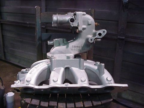 1979 Ford Bronco - A silver engine intake manifold is shown, with its firing order stamped on the side.