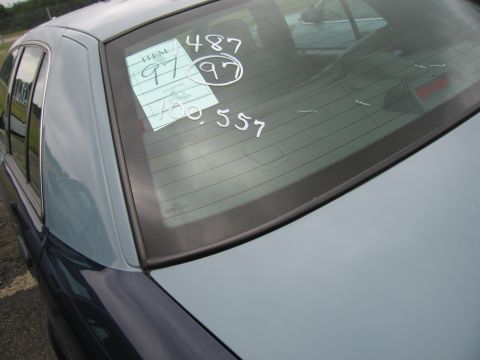 2001 Ford Crown Victoria - Photo of a car's rear window marked with handwritten auction lot numbers on a tag.