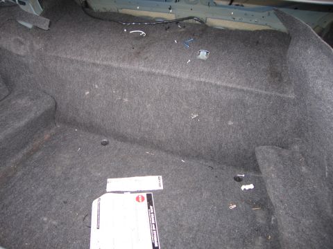 2001 Ford Crown Victoria - Photograph of a sedan's carpeted trunk interior with a paper card lying on the floor.