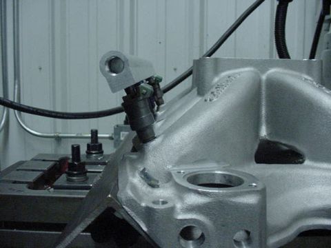 1979 Ford Bronco - A fuel injector is attached to an engine's intake manifold, showing a part of a motor project.
