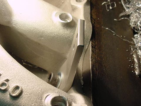 1979 Ford Bronco - Close-up of a machined metal part, possibly from an engine intake manifold, showing casting marks and the number '60'.