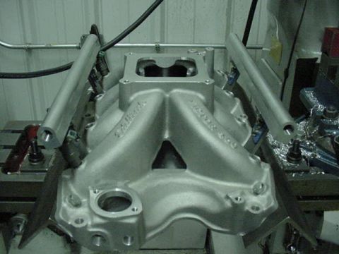 1979 Ford Bronco - Close-up of an aluminum intake manifold, likely for a V8 engine, with fuel rails attached.
