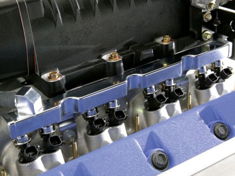 2007 Ford Mustang - Close-up photo of a physical fuel rail and injectors, not a technical document.