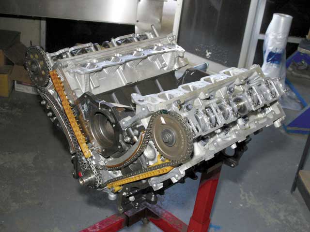 Photo of a partially assembled engine block with timing chains on a stand